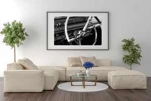 Monochrome photograph of chrome automotive controls and steering wheel.