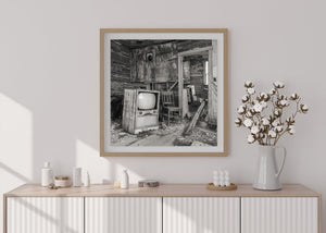 Abandoned prairie home with exposed wall lath and a vintage television.