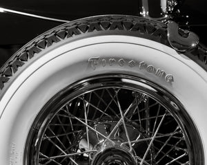 Chromspeichen unter Firestone-Schriftzug auf einem Oldtimerreifen.