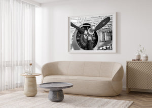 Vintage American fighter plane engine beneath hangar roof beams