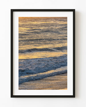Warm golden light reflected across rolling ocean waves.