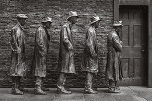 Five bronze figures waiting beside a brick wall and closed doorway.