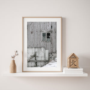Broken window and weathered boards on a Norwegian barn