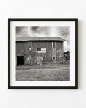 Black and white weathered barn with an American flag