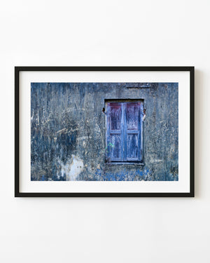Weathered blue wooden shutter on a scratched wall in India