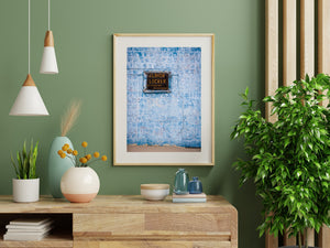 Weathered wooden sign on a textured blue wall