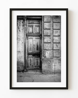 Weathered panelled wooden door in Cuba photographed in black and white