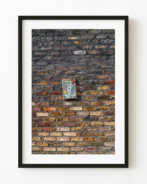 Weathered Dublin brick wall with a small battered sign