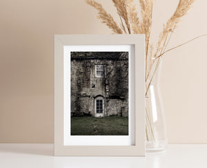 English country home with patched stonework and a grassy foreground