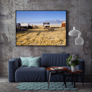 Rusty farm equipment and a weathered truck among dry grasses