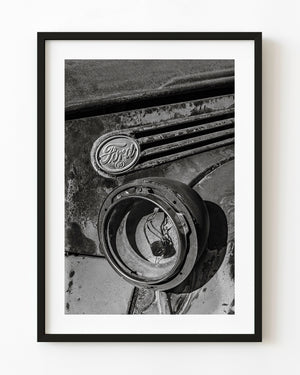 Weathered Ford badge and empty headlight housing in black and white