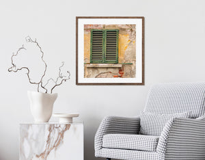 Green shutters and peeling yellow plaster in Tuscany