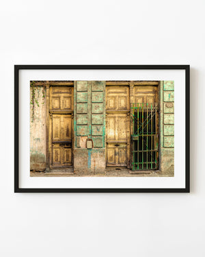 Weathered yellow wooden doors and turquoise facade in Havana