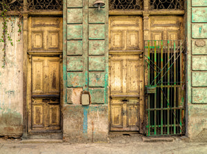 Old panelled doors beside a green iron gate in Havana