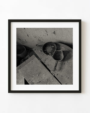 Weathered iron pans on a dusty table in the Bahamas, black and white
