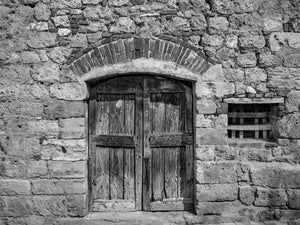 Old wooden doors set in a rough stone Italian wall