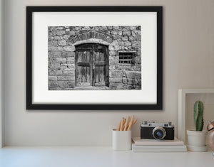 Black and white doorway with a curved brick arch and worn planks