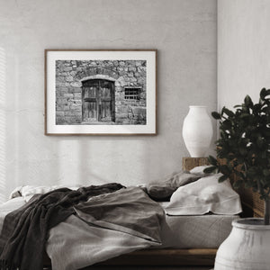 Worn wooden double doors surrounded by textured Italian masonry