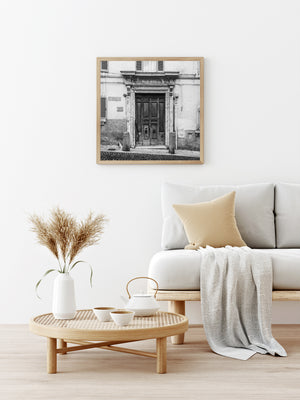 Entrada italiana desgastada con paneles de madera y bolardos de piedra