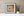 Faded orange wall surrounding a white barred window