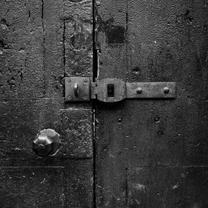 Old iron latch across a textured wooden door in London