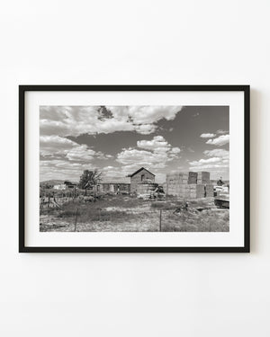 Black and white photograph of a weathered Nevada ranch and stacked hay