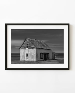 Black and white photograph of a weathered coastal house in Quebec
