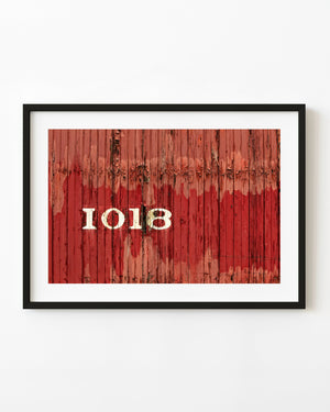 Weathered red rail car with white number 1018 and peeling paint