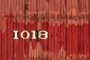 Close-up of red wooden rail car boards marked 1018