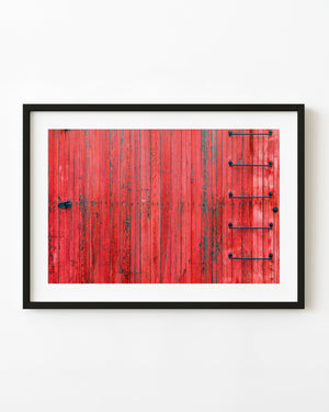 Weathered red railroad car siding with dark metal ladder rungs