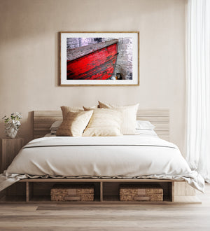 Red wooden boat with flaking paint and exposed grey timber