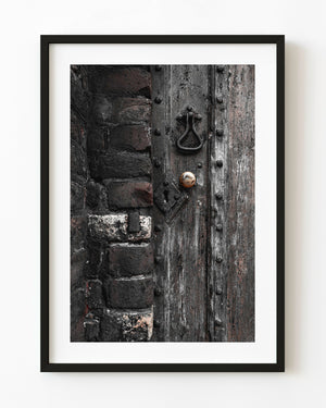 Weathered wooden door with an iron knocker in Rye, East Sussex