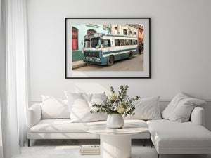 Vintage bus beside faded turquoise and cream facades in Cuba