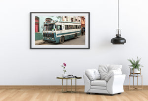Weathered Cuban public transport bus against colourful historic buildings