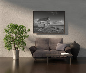 Quiet Saskatchewan grassland surrounding an old farmhouse in black and white