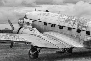 Old military transport aircraft with worn paint beneath a cloudy sky