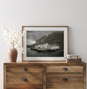 Quiet Norwegian seascape with an old waterfront hotel and steep mountain backdrop