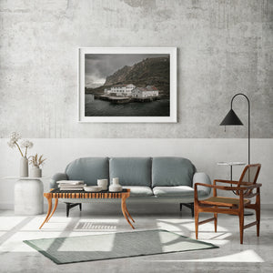 Moody photograph of a Norwegian waterfront hotel beside rippled water