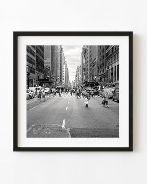 Pedestrians crossing West 39th Street in New York City in black and white