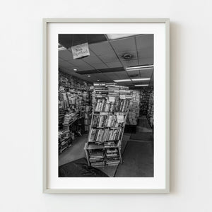 Framed black and white photograph of a bookstore interior with shelves and books.