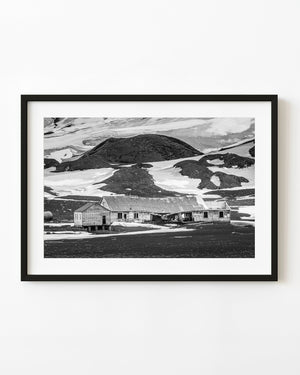 Abandoned Whalers Bay whaling station beneath snowy Antarctic hills