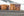 Large orange oil tanks with faded graffiti beneath an Antarctic hillside