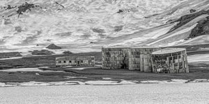 Monochrome view of rusted fuel tanks in Antarctic landscape