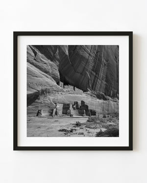 White House Ruin beneath a towering canyon cliff in black and white
