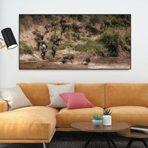 Colour wildlife photograph of wildebeest descending a dusty riverbank