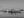 Monochrome harbour photograph of tugboats reflected in calm water