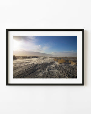 Sabbia portata dal vento su una strada nel deserto: fotografia di paesaggio a colori
