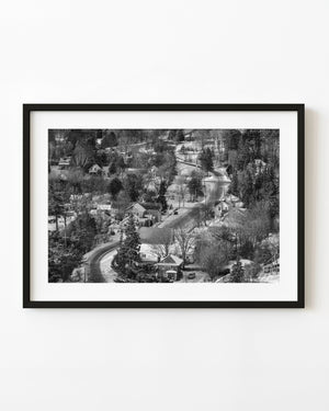 Winding winter road through Haliburton village in black and white