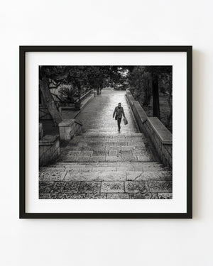 Woman ascending stone steps in Dubrovnik in black and white