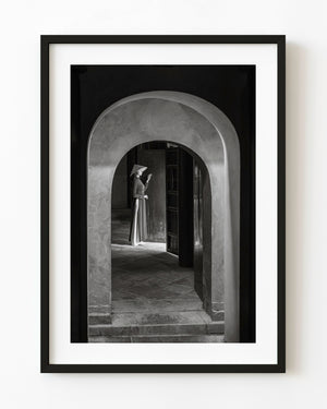 Woman beneath an arch at a Hue mausoleum in black and white